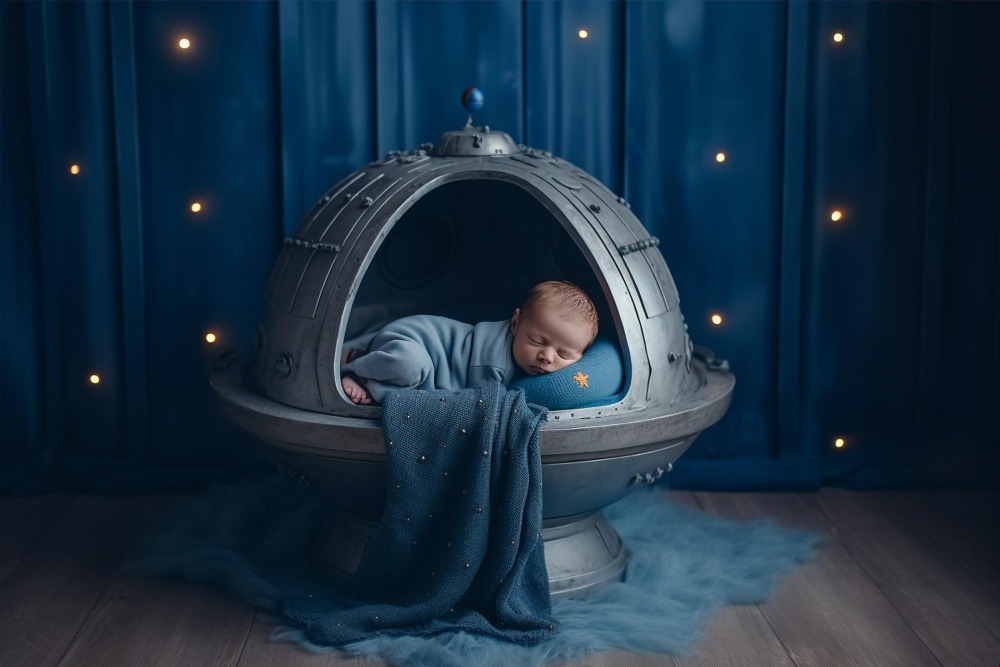 Noworodek śpiący w stylizowanej kapsule kosmicznej na tle gwieździstego nieba – sesja zdjęciowa inspirowana kosmosem