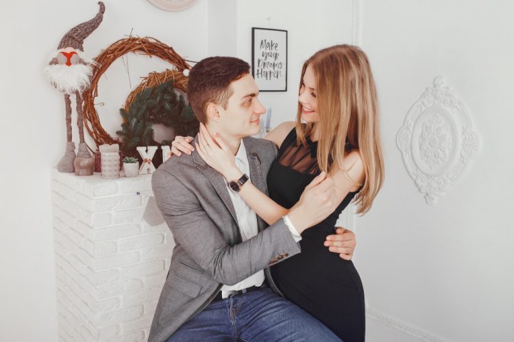 Para zakochanych w eleganckich strojach pozująca w świątecznym wnętrzu